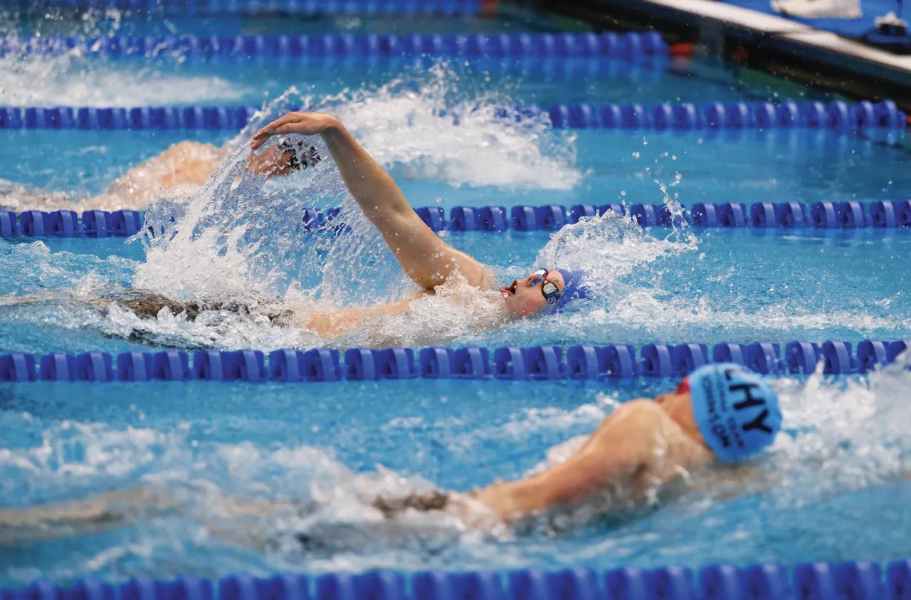 Three swimmers compete in a freestyle race