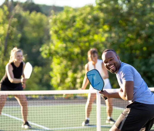 Group playing pickleball and smiling